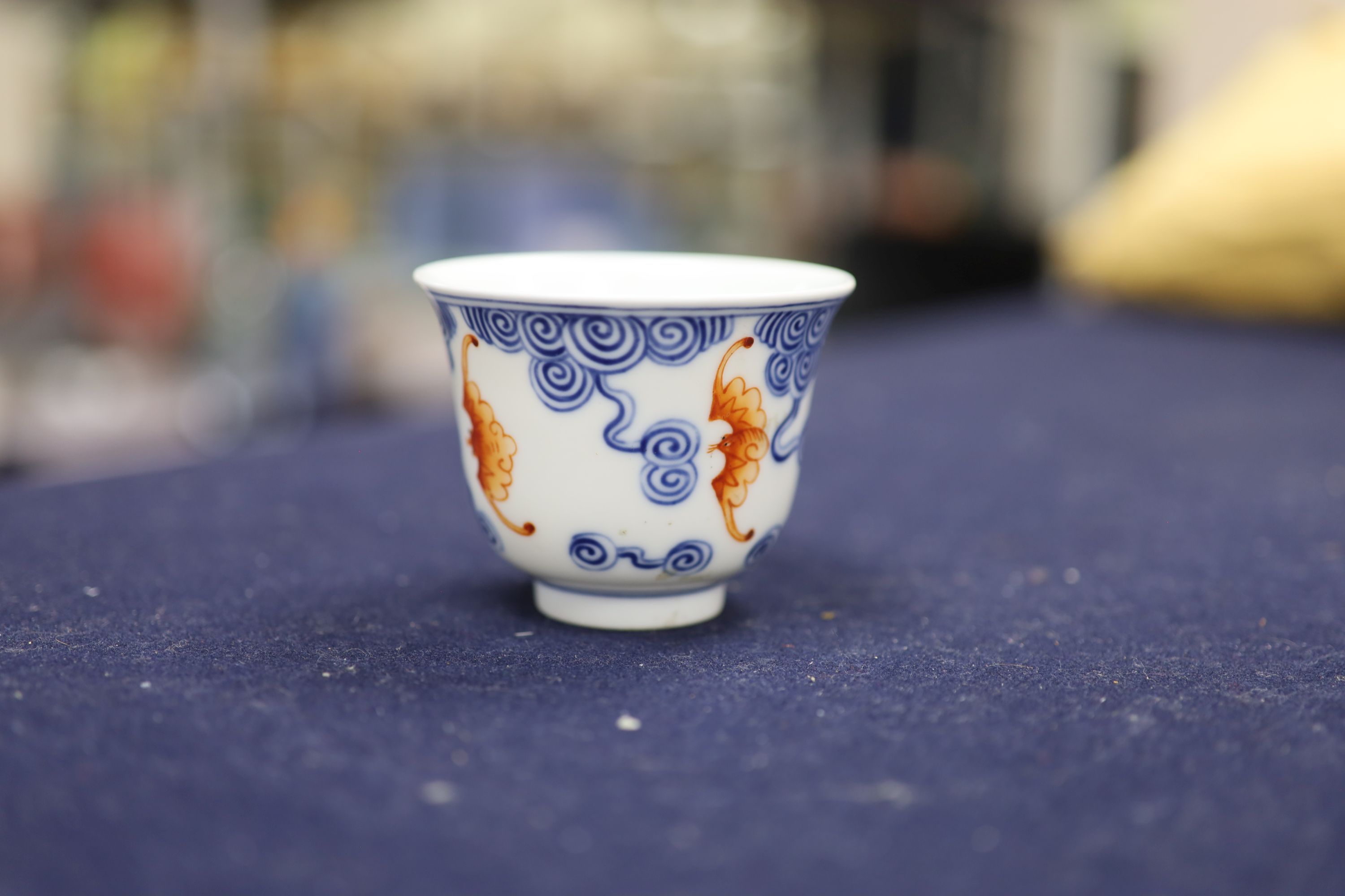 A Chinese underglaze blue and iron red 'bat' cup, height 6cm